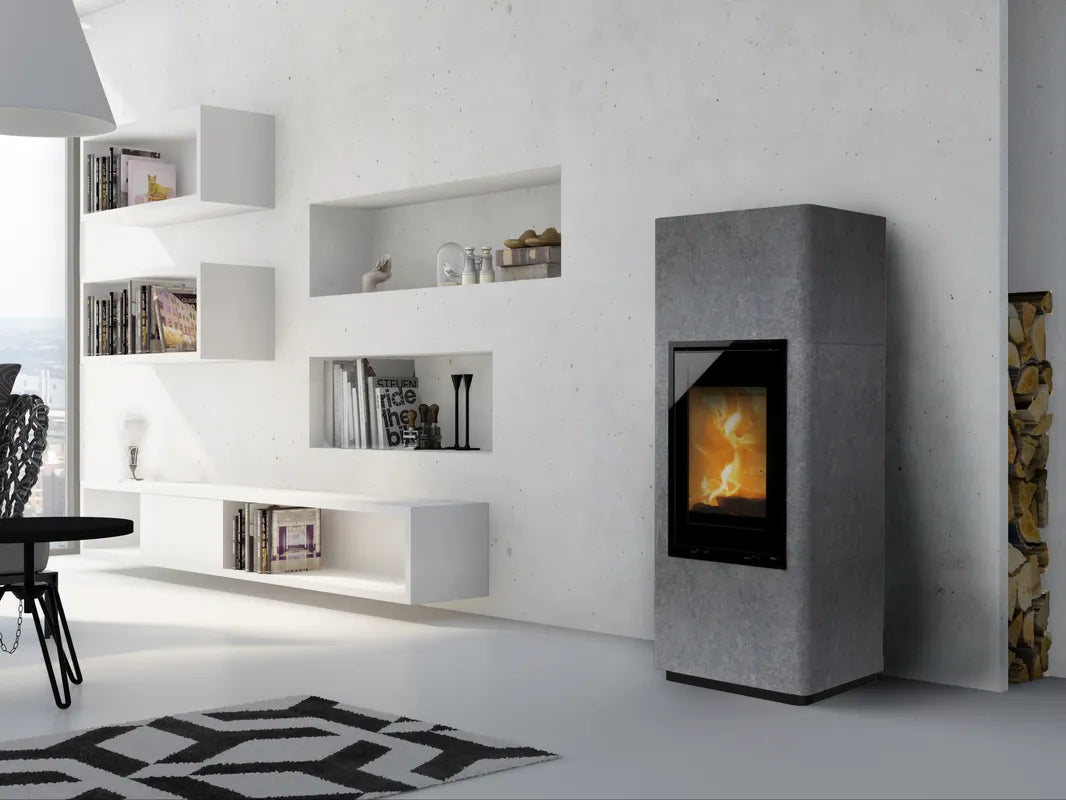 Lotus houtkachel in grijze speksteen ombouw met zwart glazen front voor moderne woonkamer en duurzame sfeervolle verwarming